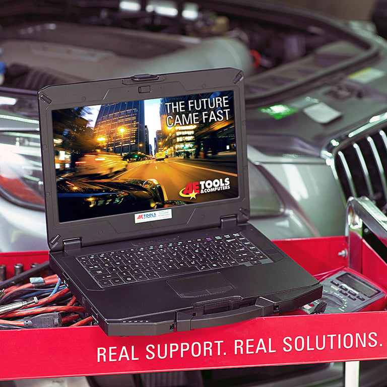Work laptop on top of bench with tools around it and a car behind